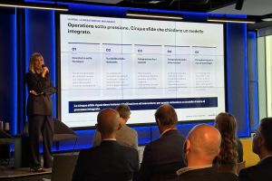Benedetta Cuttica, CEO di sedApta, parla con il microfono in mano davanti allo schermo con la slide sulle cinque sfide delle operations del mid-market, all’evento Italian Manufacturing Champions al Mixic di Assago